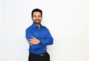 Krunal Shah, Bakelite Manager, Supply Chain in a blue shirt standing in front of a white backgorund